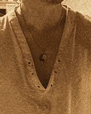 Close-up of the deep-V linen shirt and shark-tooth necklace.
